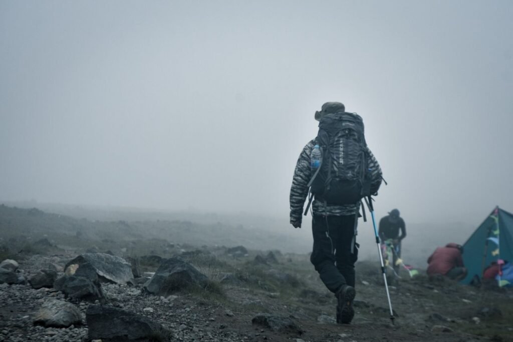 A hiker with gear treks through a foggy mountain landscape in Jawa Barat, Indonesia.